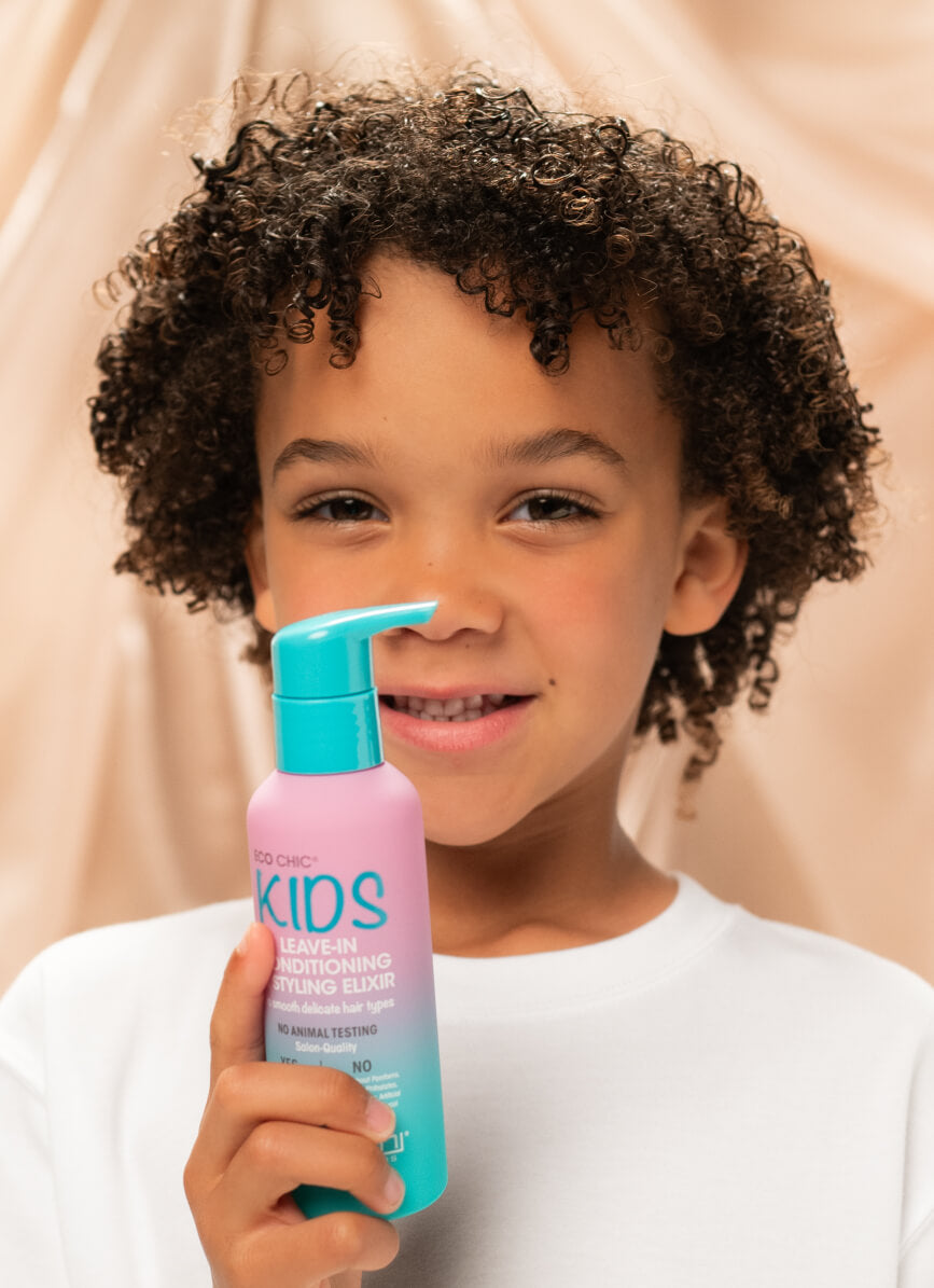 Child holding bottle of Giovanni Eco Chic Kids Leave-in Conditioning Styling Elixir