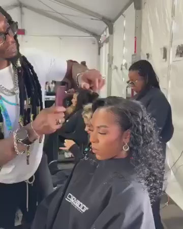 Hair stylist behind the scenes working on a model's hair