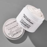 A white jar of Giovanni Cosmetics SMOOTH AS SILK XTREME™ DEEP CONDITIONING HAIR MASK, with its lid off and creamy conditioner visible inside, is displayed on a gray surface.