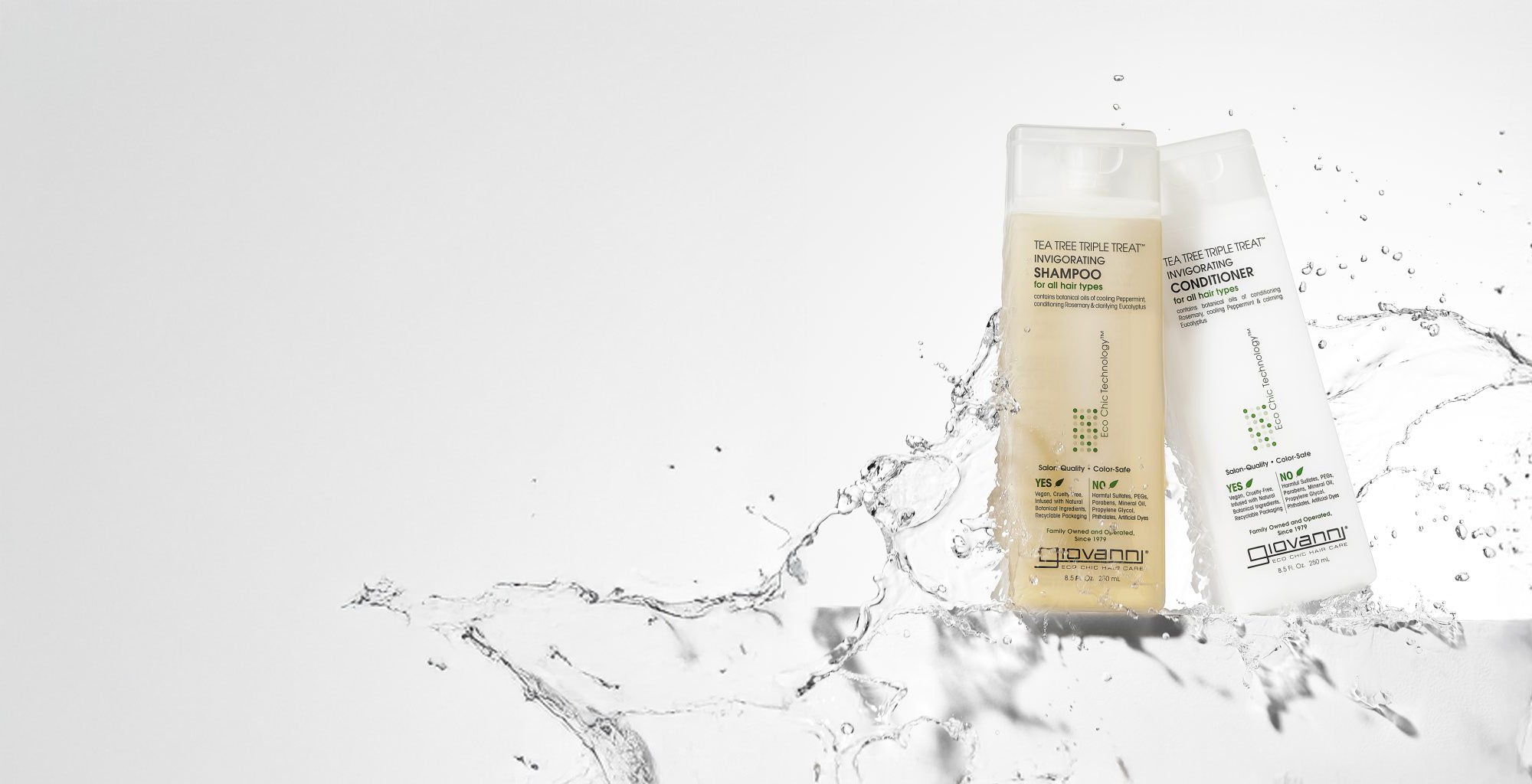 Giovanni Tea Tree Triple Treat Invigorating Shampoo and Conditioner bottles with a splash of water