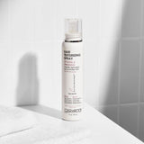A bottle of Giovanni hair texturizing spray on a white surface with light shadows.