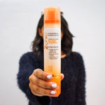 Hand holding a bottle of Giovanni 2Chic Tangerine & Papaya Butter Ultra-Volume Big Body Hair Spray